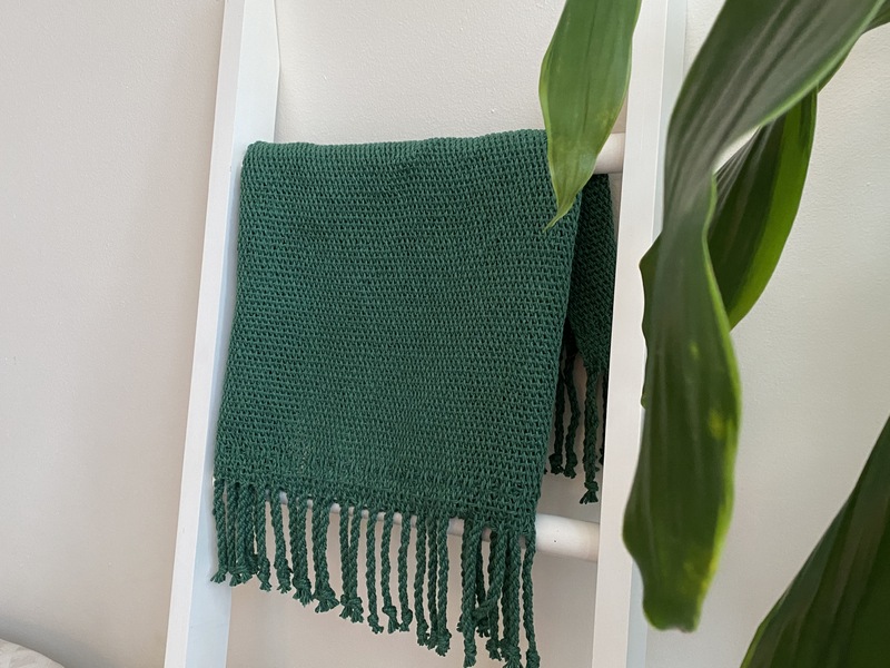 Pictured here is a woven rug, made on a 24&quot; rigid heddle loom. The item is displayed in a sunlit corner of my apartment, where I&#039;ve been learning to weave throughout 2020 and 2021. Each piece of this collection now lives with someone else in a different part of the U.S.
