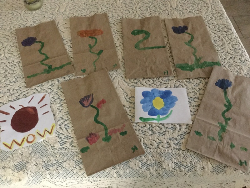 8 watercolor paintings; 5 flowers and a snake on brown paper bags, a sun and a flower on white scrap paper.